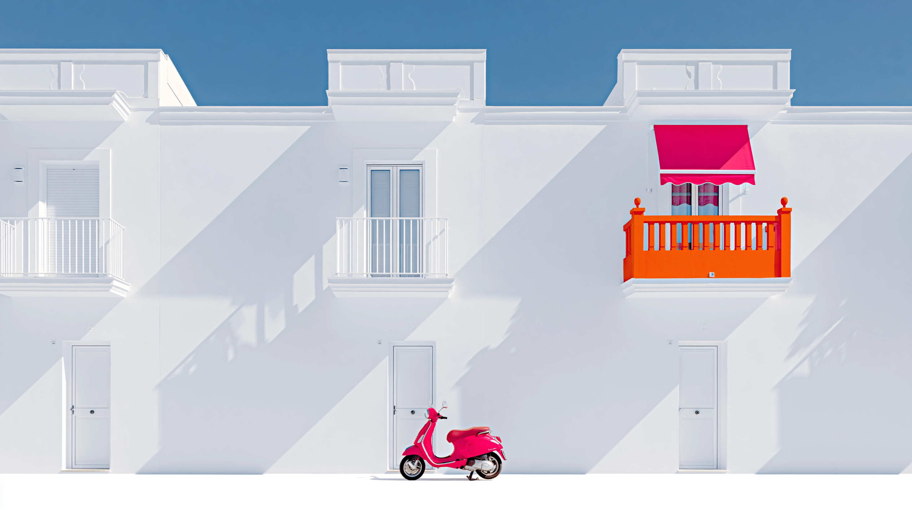 White building with an orange balcony, pink awning and pink scooter